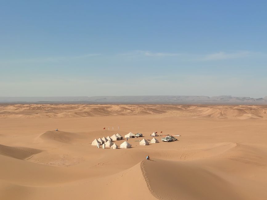 A quiet desert camp among wide sand dunes, suggesting a journey of faith and provision